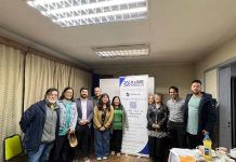 El Ministerio de Energía y la Agencia de Sostenibilidad Energética (AgenciaSE) anunciaron la adjudicación de los dos proyectos seleccionados en el concurso “Pilotos de Energía Cooperativa”, iniciativa que busca diseñar e implementar experiencias demostrativas de generación distribuida bajo un modelo asociativo y con gobernanza cooperativa. El concurso, financiado por el Ministerio de Energía, tiene como objetivo impulsar proyectos de generación solar fotovoltaica bajo la modalidad de Propiedad Conjunta, establecida en la Ley 21.118, permitiendo que un grupo de personas usuarias comparta la propiedad de un equipamiento de generación renovable y reciba los beneficios económicos de la energía inyectada a la red eléctrica, mediante descuentos en sus cuentas de electricidad. Proyecto Piloto en Temuco El proyecto adjudicado en la comuna de Temuco será implementado por la Cooperativa de Trabajo Kincha, con el patrocinio de la Cooperativa de Ahorro y Crédito Endógena Mapuche Küme Mogen, organización financiera indígena con 10 años de trayectoria y 943 socias y socios activos. La iniciativa contempla la instalación de un sistema fotovoltaico de 10 kWp en el techo de las oficinas de la cooperativa en Temuco. La planta tendrá una generación anual estimada de 11.140 kWh, permitiendo un ahorro anual proyectado de aproximadamente $1.400.000 y evitando la emisión de 67 tCO₂eq durante su vida útil. Las personas beneficiarias directas serán cinco socias y socios fundadores de la cooperativa Küme Mogen, quienes han sido priorizados bajo criterios internos de solidaridad, junto con el empalme eléctrico que abastece las oficinas de la propia cooperativa. Se estima un ahorro promedio anual de $192.000 por persona beneficiaria, junto con la constitución de un fondo colectivo para operación y mantenimiento. Küme Mogen es la primera cooperativa mapuche de ahorro y crédito del país, orientada al fortalecimiento del desarrollo económico y cultural del Wallmapu. Su misión se sustenta en el azmapu —ética propia mapuche— promoviendo el desarrollo endógeno, la reciprocidad (keyuwün) y el buen vivir (küme mogen). El proyecto energético surge como una estrategia para ampliar las herramientas de desarrollo económico frente al alza sostenida de las tarifas eléctricas y la creciente pobreza energética. Las personas beneficiarias indirectas incluyen al conjunto de los 943 socias y socios de la cooperativa y a las comunidades del Wallmapu donde esta tiene presencia, quienes podrán participar en instancias formativas y de difusión en energías renovables y gestión comunitaria. Más allá del impacto económico, el proyecto fortalece capacidades organizativas y técnicas con pertinencia cultural, proyectándose como el primer paso hacia la futura conformación de una cooperativa de energía. Proyecto Piloto en Macul En la comuna de Macul, el proyecto será ejecutado por la Cooperativa de Trabajo Red Genera, con el patrocinio de la Cooperativa Solar N°1 de Macul. La iniciativa contempla la instalación de una planta solar de 20 kWp en el techo del Gimnasio Municipal de Macul. La generación anual estimada es de 28.300 kWh, lo que se traduce en un beneficio económico anual cercano a $3.000.000. Las personas beneficiarias directas serán 22 familias vecinas de Macul y la Junta de Vecinos de Villa Santa Carolina, que representa a aproximadamente 1.200 viviendas. La energía inyectada será repartida en partes iguales (4,34% por persona usuaria), generando un descuento anual estimado de $130.000 por persona beneficiaria. Cada socio y socia aportará $20.000 anuales para cubrir los costos de operación y mantenimiento, totalizando un fondo de $500.000, gestionado por la cooperativa y rendido ante su asamblea. Un elemento central del proyecto es la colaboración de la Ilustre Municipalidad de Macul, que pone a disposición parte del techo del gimnasio municipal para el desarrollo de esta iniciativa cooperativa. Esta alianza público-comunitaria representa un hito en la promoción de la participación ciudadana en la transición energética, facilitando el uso de infraestructura pública para fines comunitarios y ambientales. Con este proyecto, Macul consolida una experiencia demostrativa de transición energética local, en la que municipio y ciudadanía cooperan para democratizar el acceso a la energía renovable y fortalecer el desarrollo territorial sostenible.